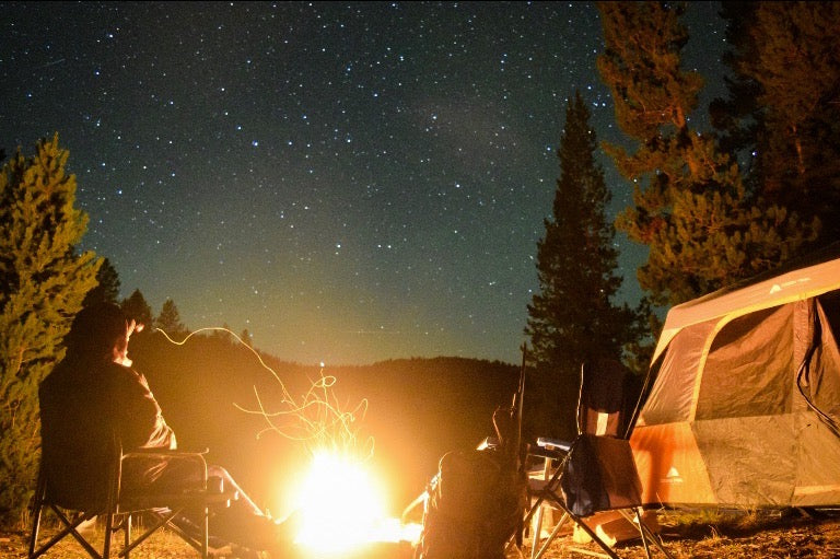Thrillside crew sitting next to a fire in camp under the stars